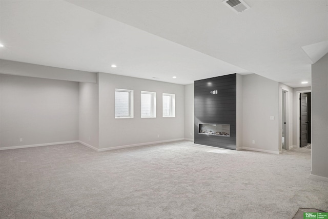 unfurnished living room featuring light carpet, baseboards, visible vents, a fireplace, and recessed lighting