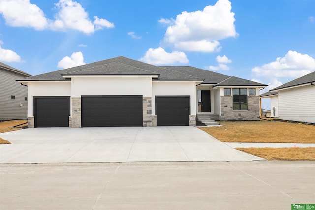 prairie-style home featuring an attached garage, stone siding, concrete driveway, and stucco siding