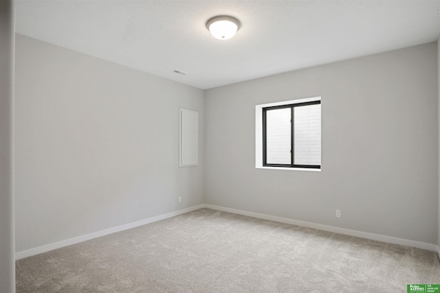 carpeted empty room with visible vents and baseboards