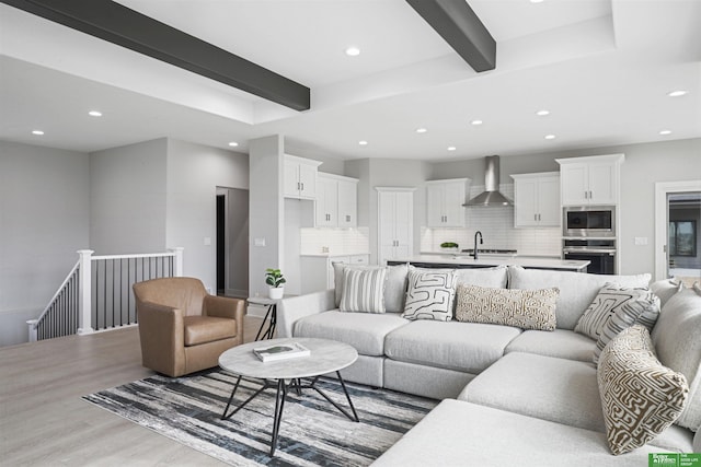 living area with light wood finished floors, beam ceiling, and recessed lighting