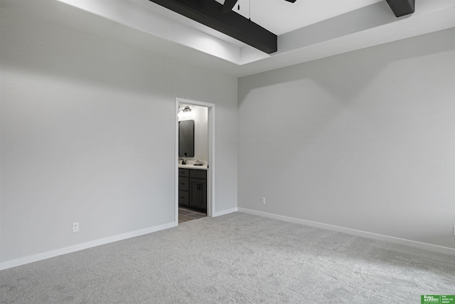 carpeted spare room with ceiling fan, baseboards, and beam ceiling