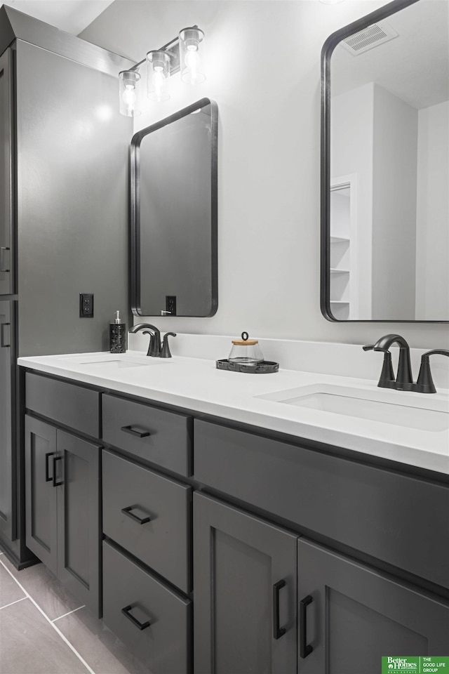 full bathroom with double vanity, visible vents, a sink, and tile patterned floors