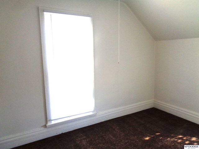 bonus room with vaulted ceiling and baseboards