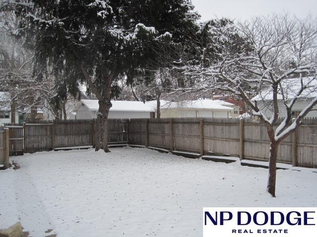 yard layered in snow with a fenced backyard