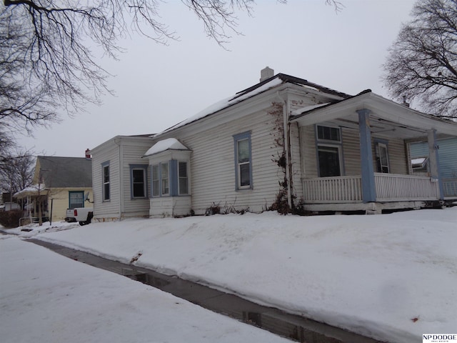 view of front of home with a porch and a chimney