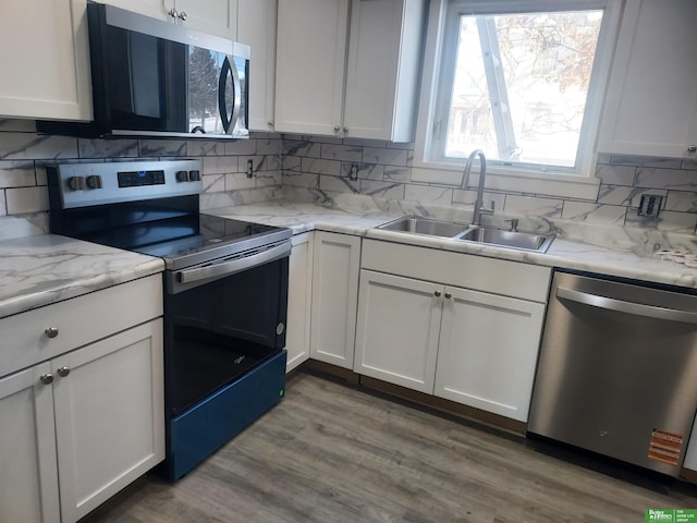 kitchen featuring appliances with stainless steel finishes, white cabinets, and a sink