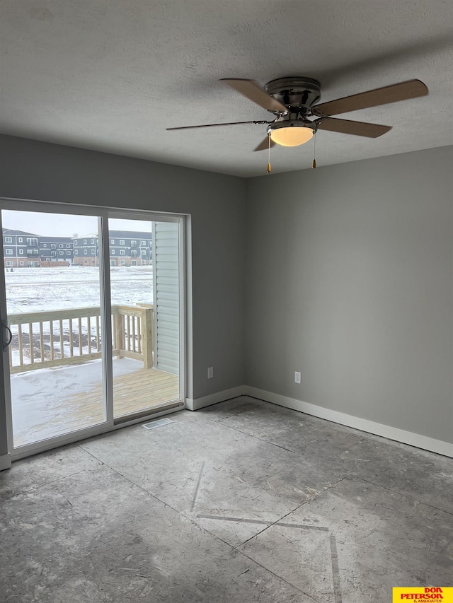 unfurnished room with a view of city, visible vents, a textured ceiling, and baseboards