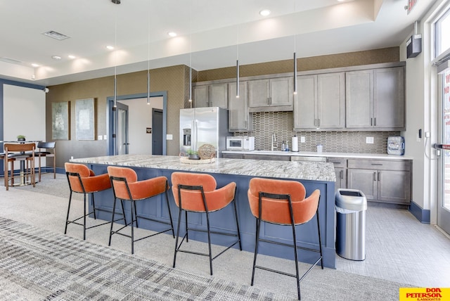 3593 Little Bluestem Rd, Fremont, NE 68025 - kitchen featuring stainless steel refrigerator with ice dispenser, light colored carpet, a breakfast bar area, a center island, and recessed lighting