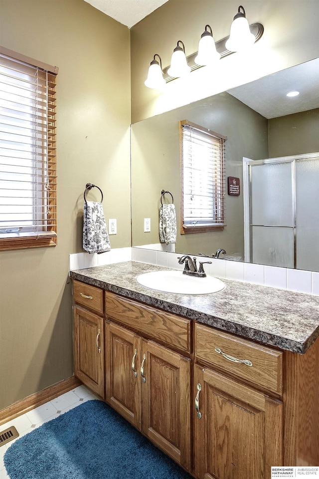 bathroom with vanity, tile patterned floors, visible vents, and a stall shower