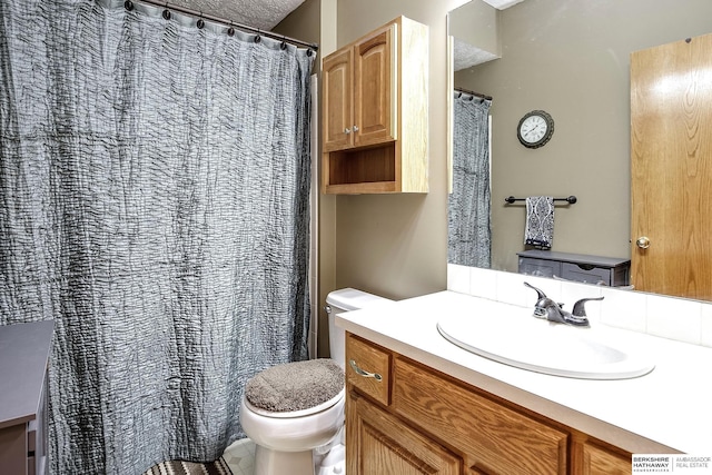 full bathroom featuring toilet, vanity, and a textured ceiling