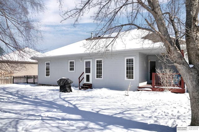 snow covered house with fence and entry steps