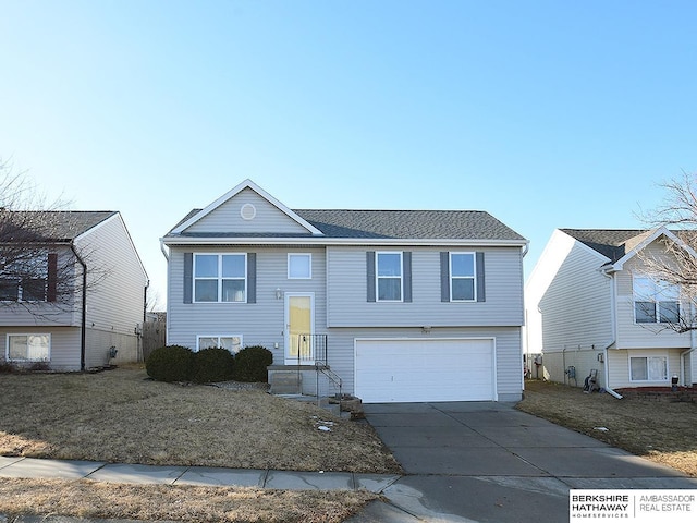 split foyer home featuring concrete driveway and an attached garage