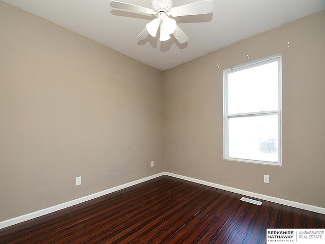 unfurnished room featuring baseboards, visible vents, ceiling fan, and dark wood-style flooring