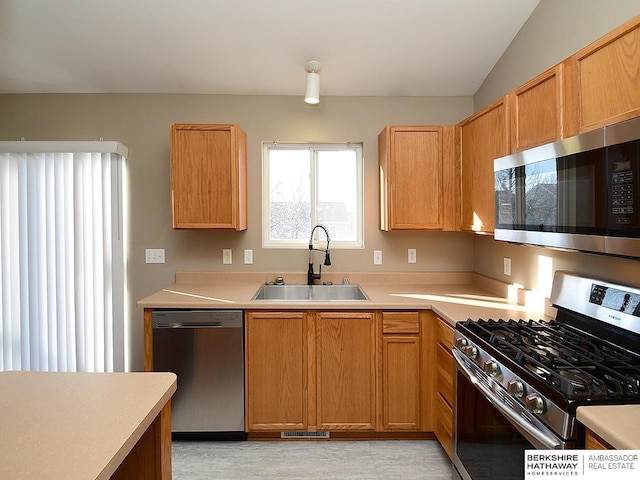 kitchen with light countertops, appliances with stainless steel finishes, a sink, and visible vents