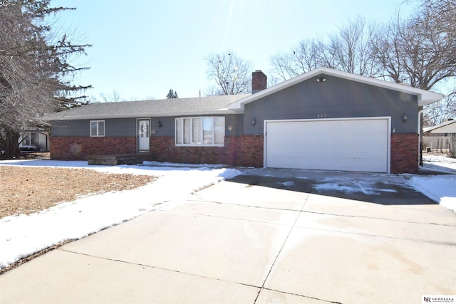 ranch-style house featuring a garage, concrete driveway, brick siding, and a chimney