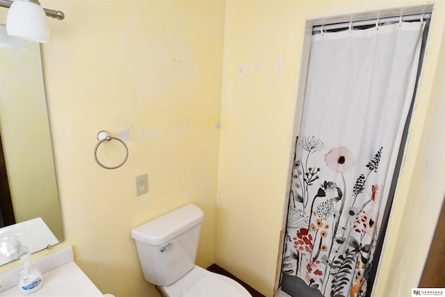 bathroom featuring a shower with shower curtain and toilet