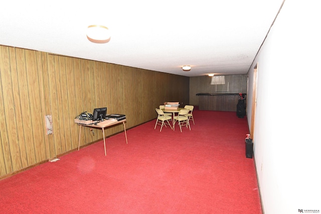 interior space featuring dark colored carpet and wood walls