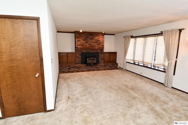 unfurnished living room with a textured ceiling, carpet floors, and baseboards