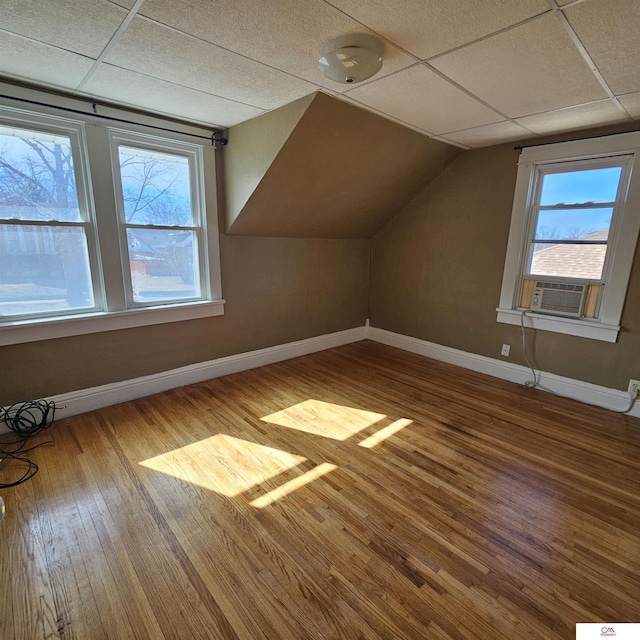 bonus room with vaulted ceiling, cooling unit, wood finished floors, and baseboards