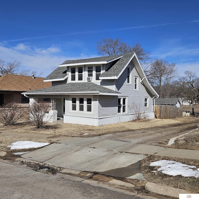 view of front of property featuring a shingled roof and fence