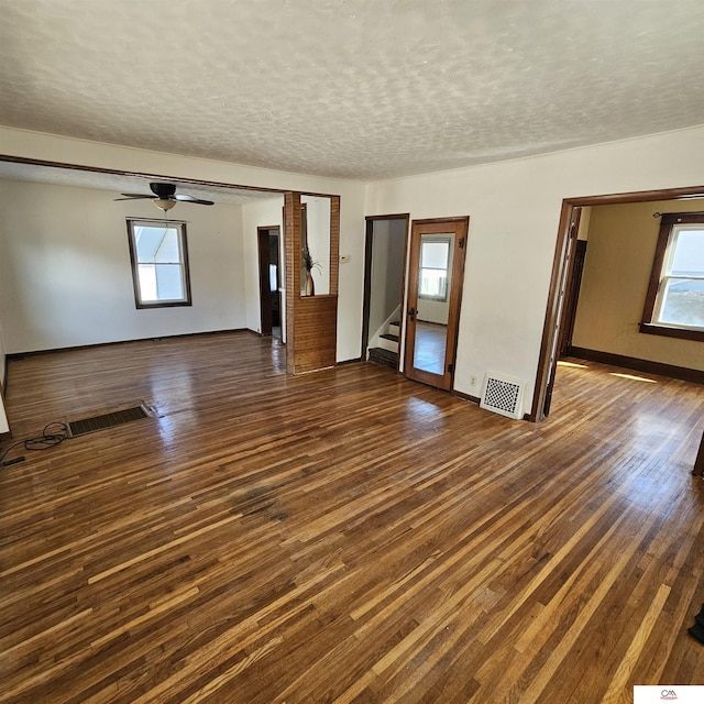 interior space with a wealth of natural light, dark wood-style flooring, and visible vents