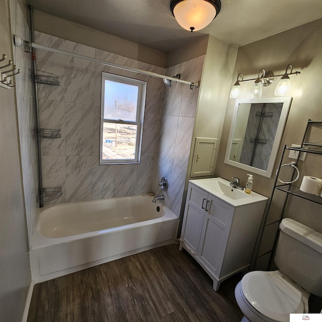 bathroom with washtub / shower combination, vanity, toilet, and wood finished floors