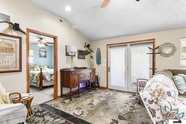 interior space featuring dark carpet, visible vents, vaulted ceiling, and a ceiling fan