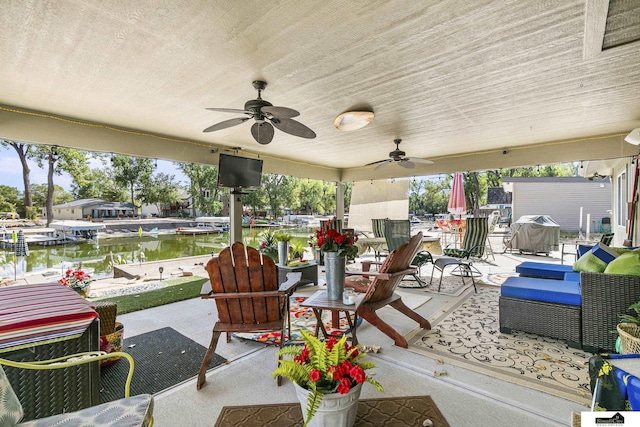 view of patio with a water view, an outdoor hangout area, and a ceiling fan