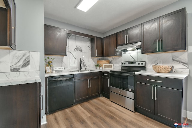 kitchen featuring black dishwasher, light countertops, a sink, under cabinet range hood, and stainless steel electric range