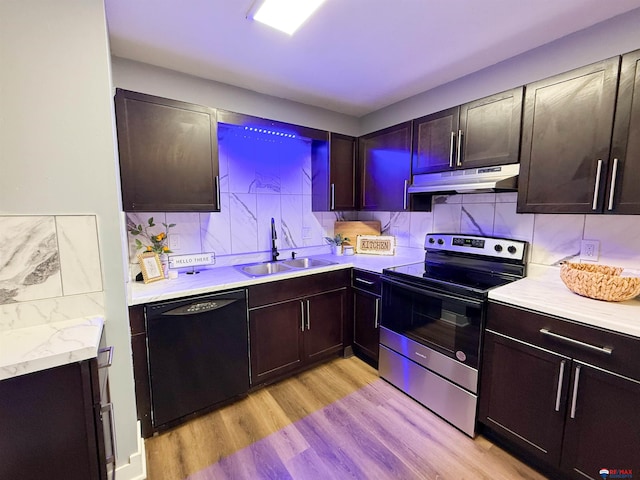 kitchen featuring under cabinet range hood, a sink, black dishwasher, light countertops, and stainless steel electric range