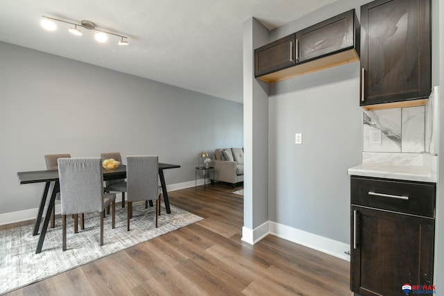 dining room featuring dark wood finished floors and baseboards