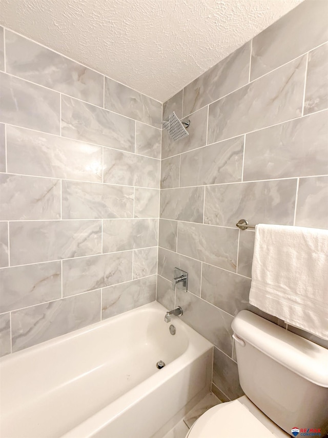 full bath featuring a textured ceiling,  shower combination, toilet, and tile walls