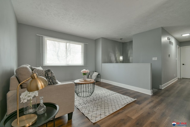 living area with visible vents, baseboards, and dark wood-style flooring