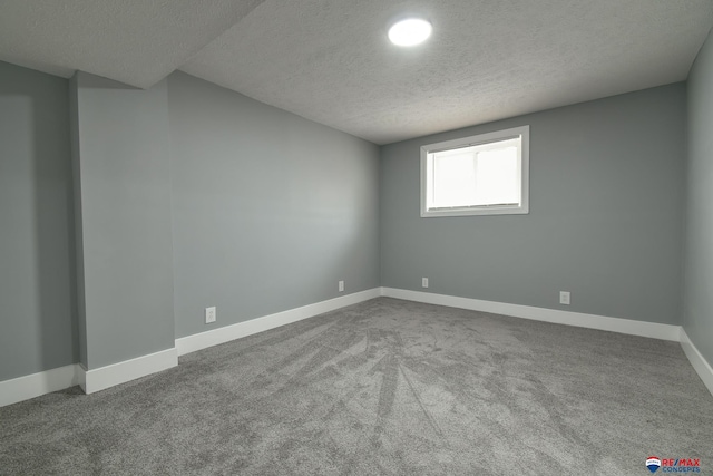 spare room featuring a textured ceiling, baseboards, and carpet flooring