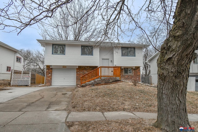 split foyer home featuring concrete driveway, brick siding, and an attached garage