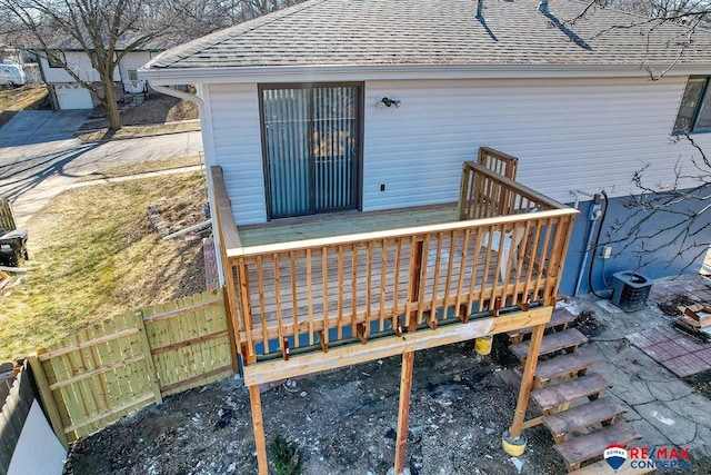 exterior space featuring a deck, central AC unit, roof with shingles, and fence