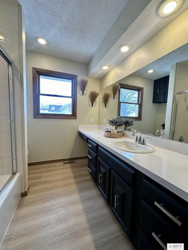 bathroom featuring baseboards, vanity, a textured ceiling, and wood finished floors