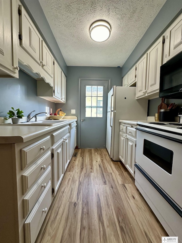 kitchen featuring light wood-type flooring, white appliances, white cabinetry, and light countertops