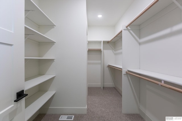 spacious closet featuring visible vents and light carpet