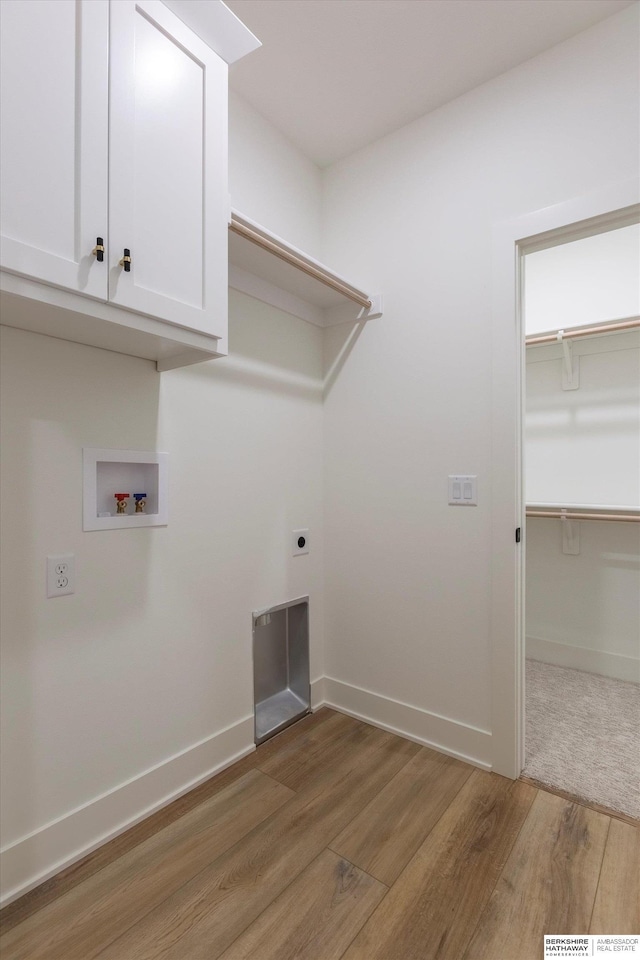 laundry room featuring cabinet space, baseboards, wood finished floors, washer hookup, and electric dryer hookup