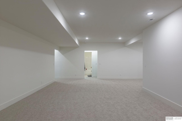 finished below grade area with baseboards, light colored carpet, and recessed lighting