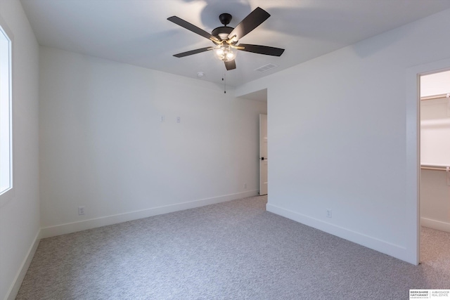 interior space featuring light carpet, visible vents, a spacious closet, and baseboards