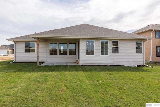 back of house featuring a patio area, roof with shingles, and a yard