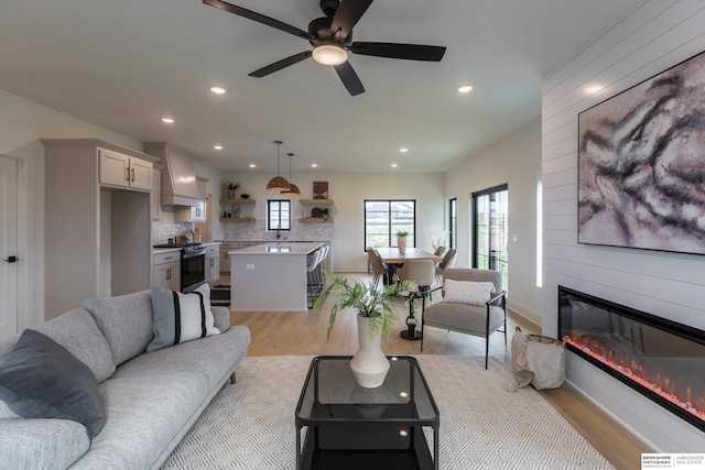 living area with light wood finished floors, a fireplace, and a wealth of natural light