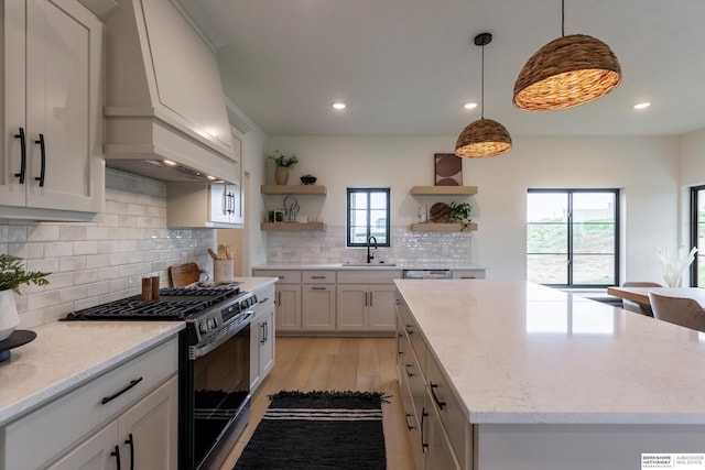 kitchen featuring a center island, white cabinetry, open shelves, and gas stove