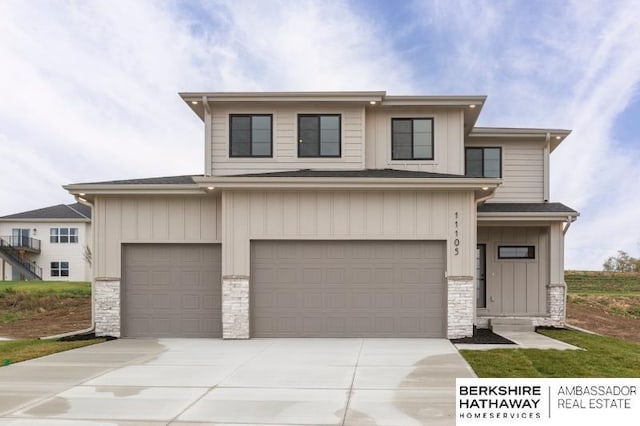 view of front of house with a garage, stone siding, board and batten siding, and concrete driveway