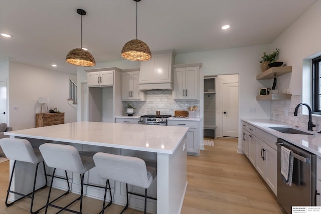 kitchen featuring white cabinets, a sink, custom exhaust hood, and open shelves