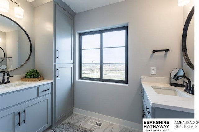 full bathroom with two vanities, visible vents, and a sink