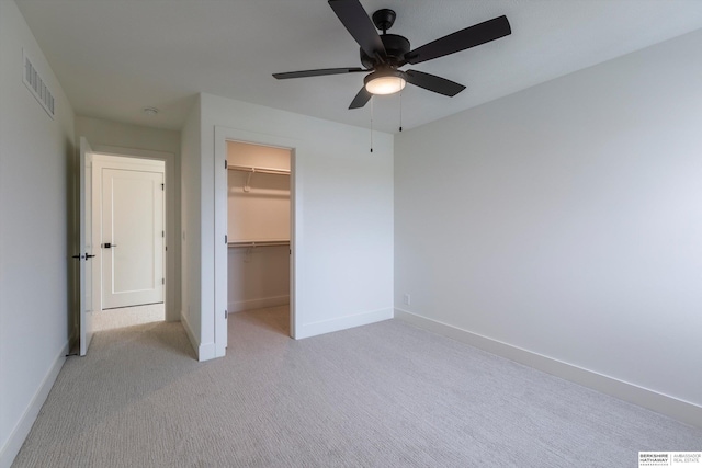 unfurnished bedroom with light carpet, visible vents, baseboards, a spacious closet, and a closet