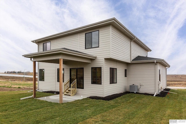 back of house with entry steps, a yard, and a patio area